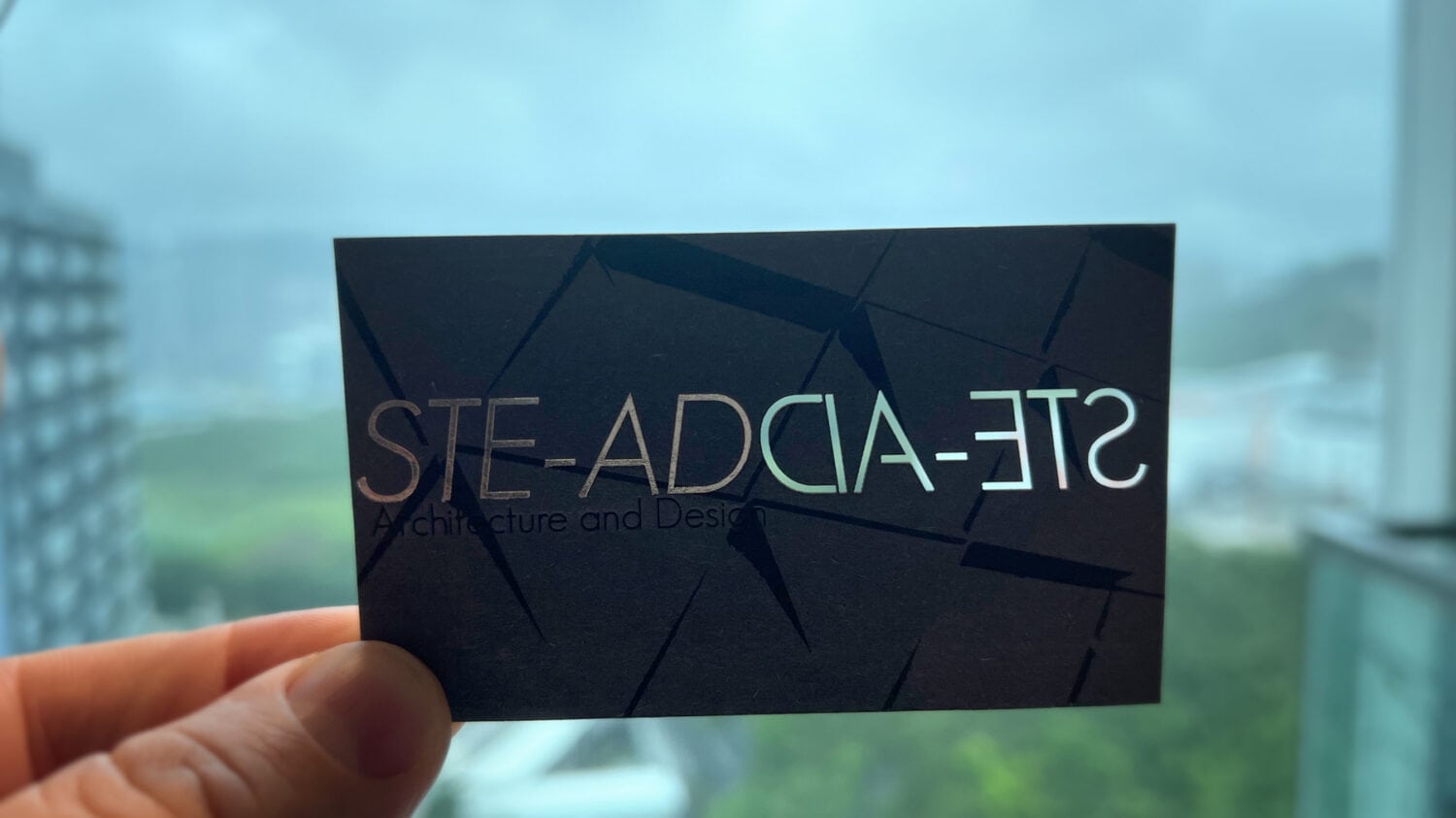 STE-AD Business Card with Cut Hole Letters in front of green landscape Photo - Contact Us for a Free Consultation