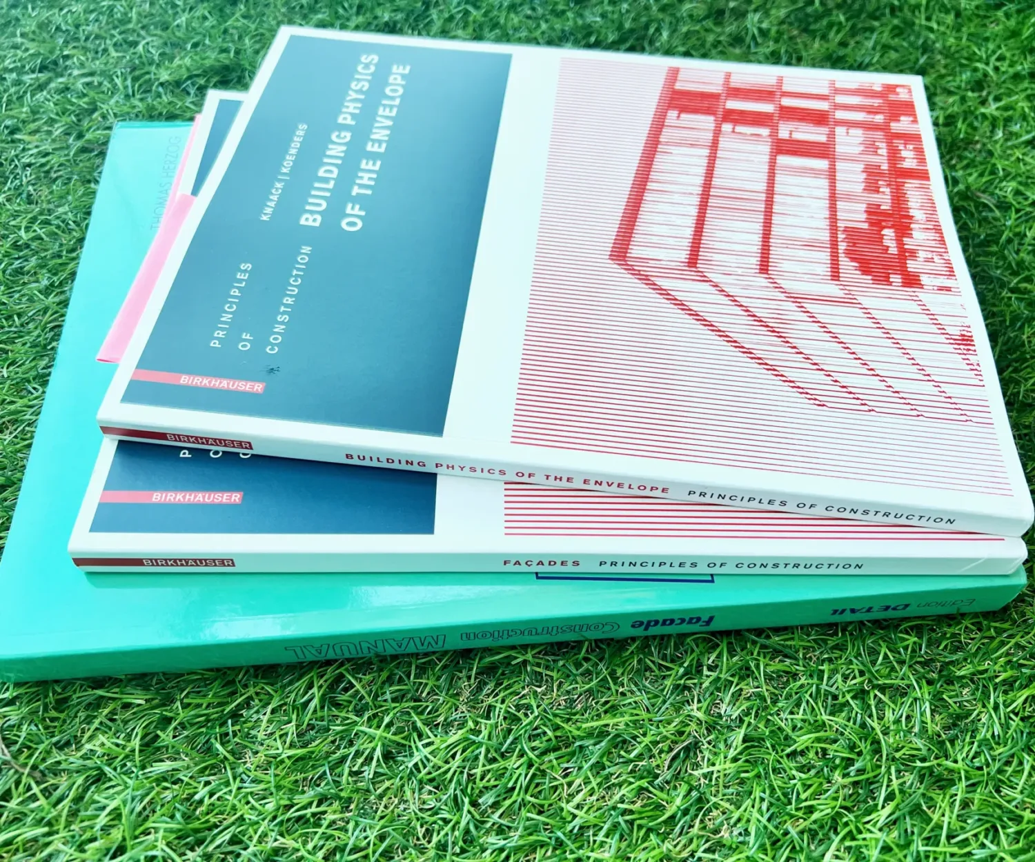Picture of facade construction and architectural design reference books on green grass turf